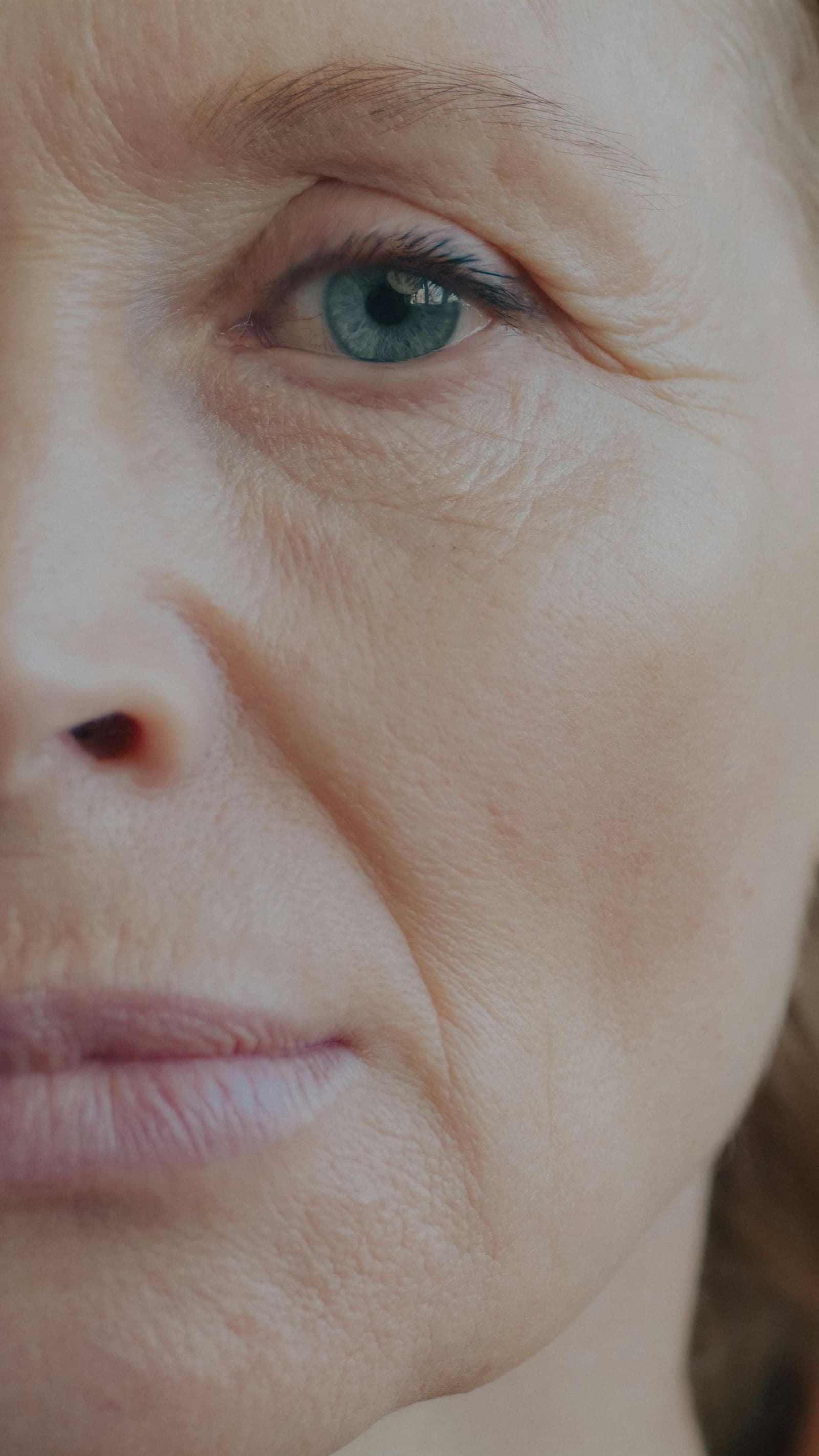 Close-up of a mature woman's face showing fine lines around her blue eye