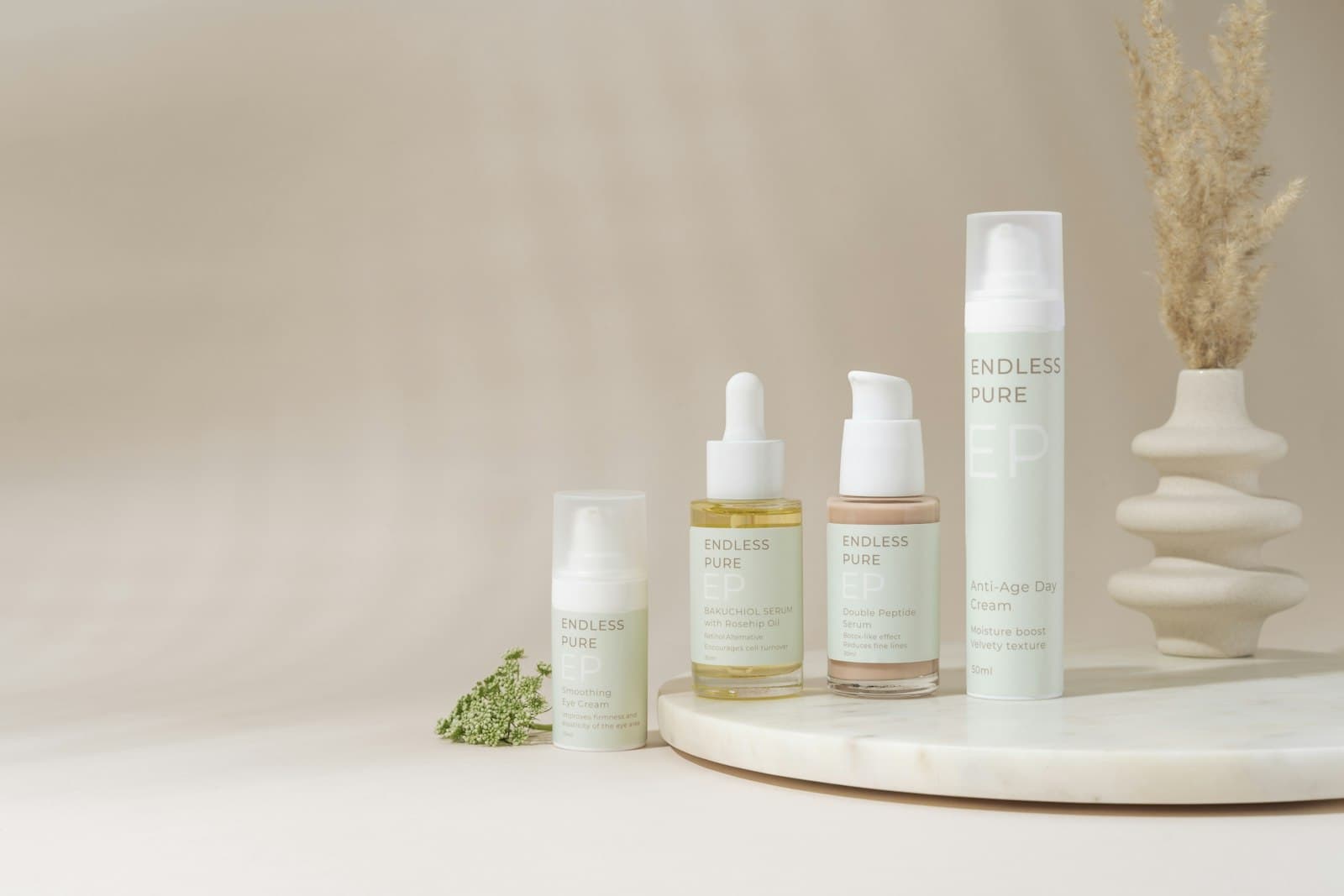 Minimal set of skincare bottles and a pump moisturizer on a light marble tray