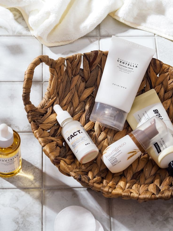 A few simple skincare bottles and a pump moisturizer on a wooden tray in soft neutral light
