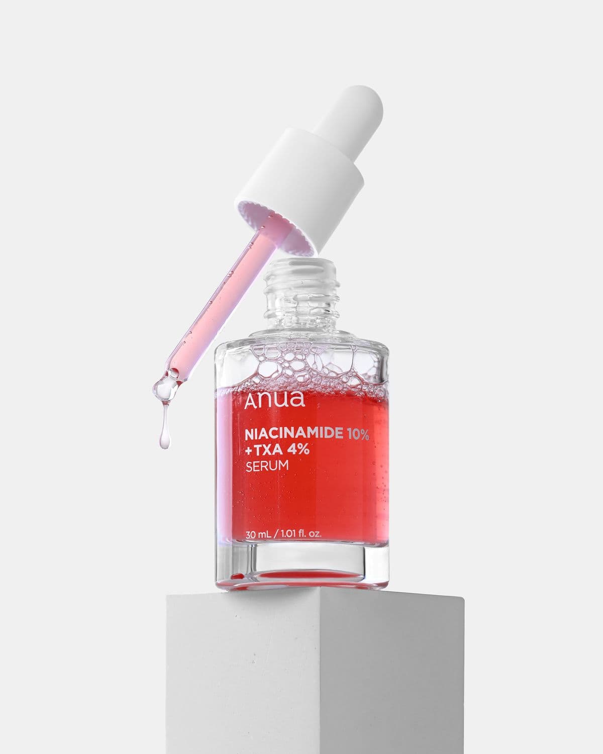 Clear serum dripping from a glass dropper into an open palm