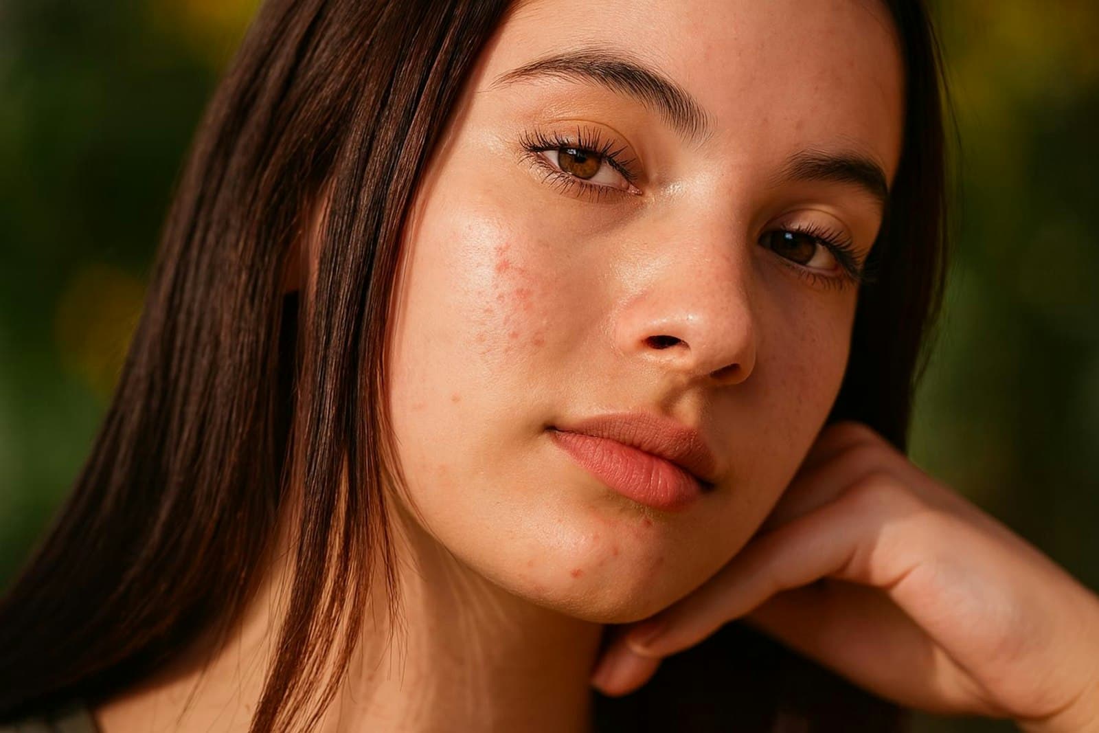 Close-up of a young woman's bare face showing natural skin texture on her cheeks, nose and forehead