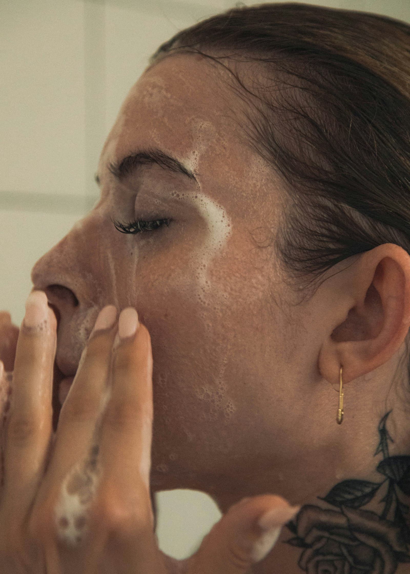 Woman massaging a cleanser into her face with her fingertips