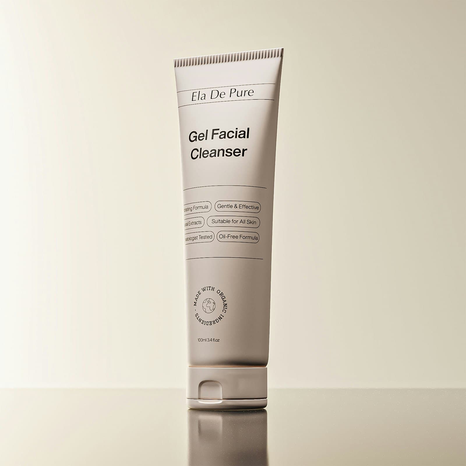 Tube of gel facial cleanser standing on a glossy cream surface
