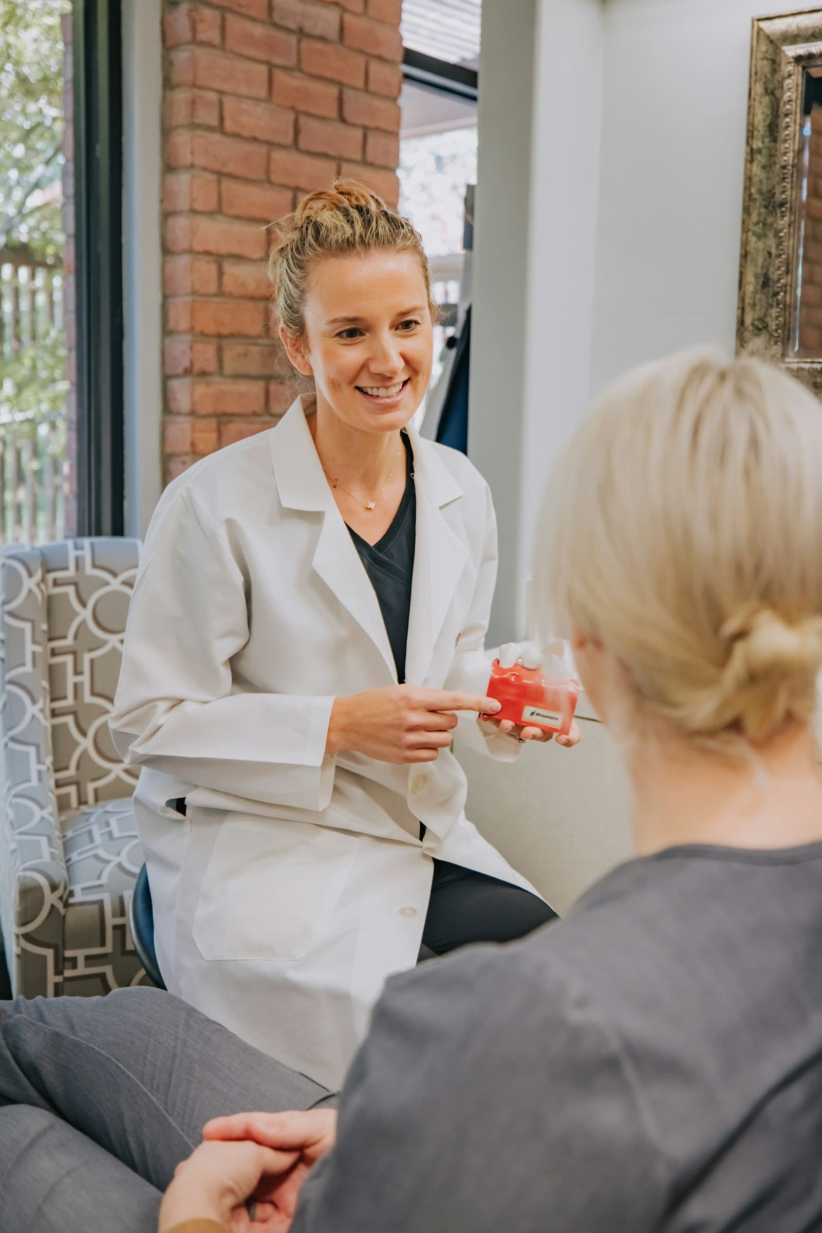 Skin professional in a white coat talking with a client during a consultation